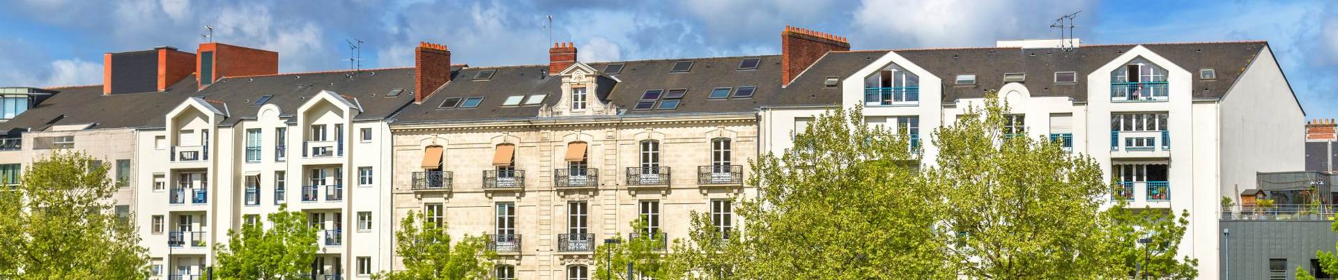 Façades d'immeubles anciens en pierre avec balcons, bannière de la page diagnostic plomb