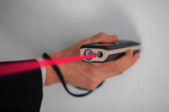 Main utilisant un télémètre laser à faisceau rouge, mesurage de la superficie Carrez